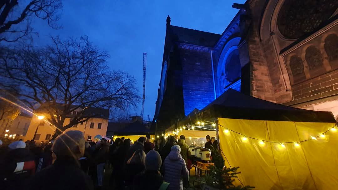 Leubener Weihnachtsmarkt mit farbig beleuchteter Kirche